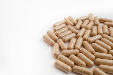 Beyaz arka planda kahverengi kapsül hapları