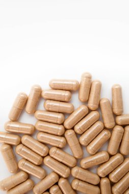 Beyaz arka planda kahverengi kapsül hapları