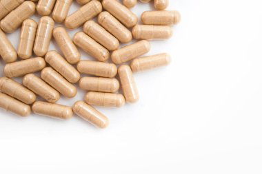 Beyaz arka planda kahverengi kapsül hapları