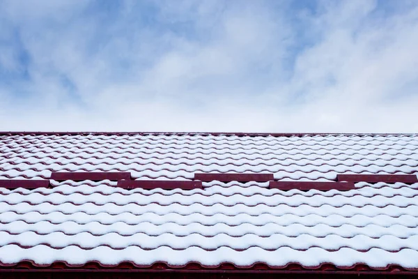 Mavi gökyüzüne karşı karda bir çatı