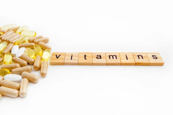 Vitamine Iscrizione Cubi Legno Uno Sfondo Bianco Diverse Pillole — Foto Stock