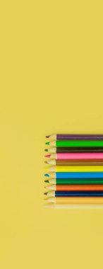 Sarı panorama arka planında renkli kalemler