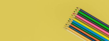 Sarı panorama arka planında renkli kalemler
