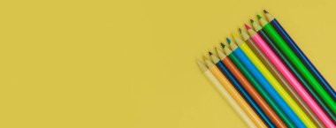 Sarı panorama arka planında renkli kalemler