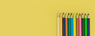 Sarı panorama arka planında renkli kalemler