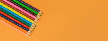 Sarı panorama arka planında renkli kalemler