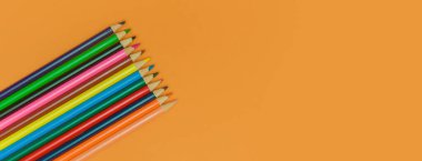 Sarı panorama arka planında renkli kalemler