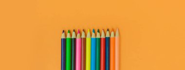 Sarı panorama arka planında renkli kalemler