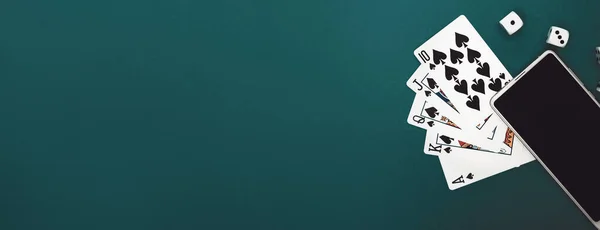 Yeşil mavi kumaş panoramada poker zarları ve telefon oyunu