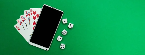 Yeşil mavi kumaş panoramada poker zarları ve telefon oyunu