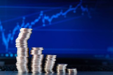 Bir dizüstü bilgisayarın arkaplanında grafikler şeklinde sikkeler