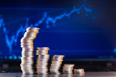 Bir dizüstü bilgisayarın arkaplanında grafikler şeklinde sikkeler