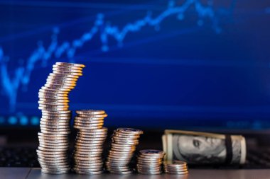 Bir dizüstü bilgisayarın arkaplanında grafikler şeklinde sikkeler