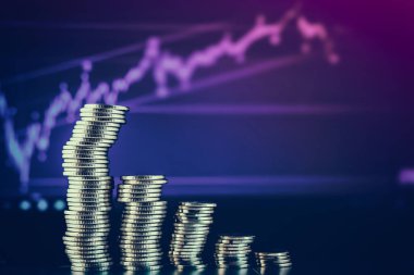 Bir dizüstü bilgisayarın arkaplanında grafikler şeklinde sikkeler