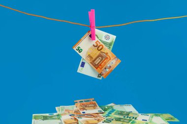 Euero parası mavi arka planda halat mandalına