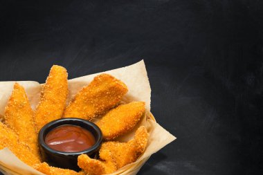 Siyah arka planda tabaklar üzerinde fast food