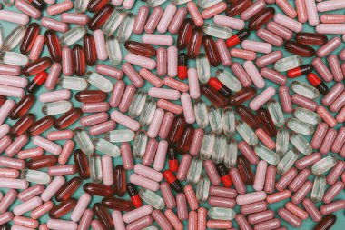 yeşil arka planda çok renkli haplar ve kapsüller