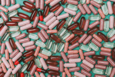 yeşil arka planda çok renkli haplar ve kapsüller