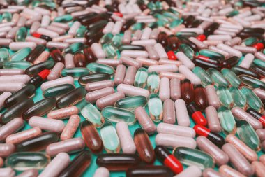 yeşil arka planda çok renkli haplar ve kapsüller