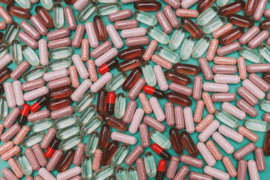 yeşil arka planda çok renkli haplar ve kapsüller