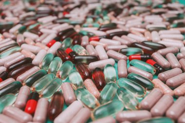 yeşil arka planda çok renkli haplar ve kapsüller