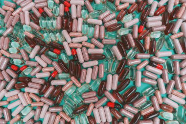 yeşil arka planda çok renkli haplar ve kapsüller