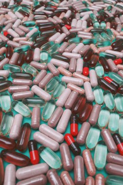 yeşil arka planda çok renkli haplar ve kapsüller