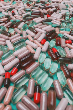 yeşil arka planda çok renkli haplar ve kapsüller