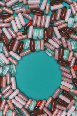 yeşil arka planda çok renkli haplar ve kapsüller