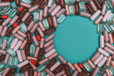 yeşil arka planda çok renkli haplar ve kapsüller