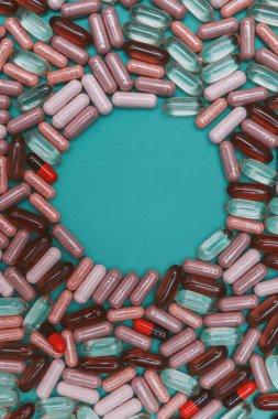 yeşil arka planda çok renkli haplar ve kapsüller