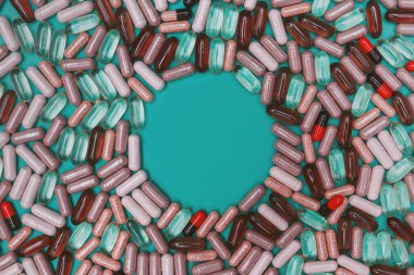 yeşil arka planda çok renkli haplar ve kapsüller