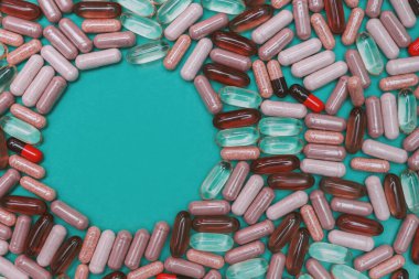 yeşil arka planda çok renkli haplar ve kapsüller