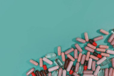 yeşil arka planda çok renkli haplar ve kapsüller