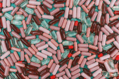 yeşil arka planda çok renkli haplar ve kapsüller