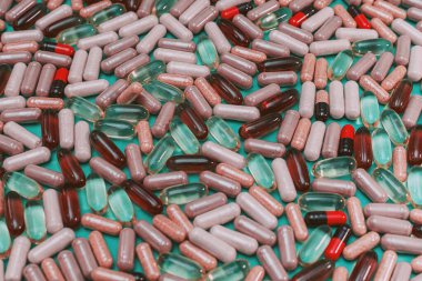 yeşil arka planda çok renkli haplar ve kapsüller