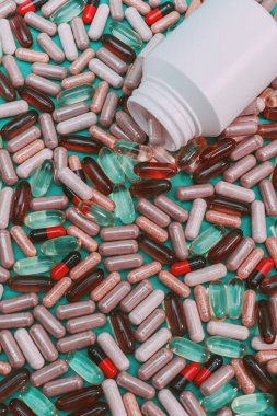 yeşil arka planda çok renkli haplar ve kapsüller
