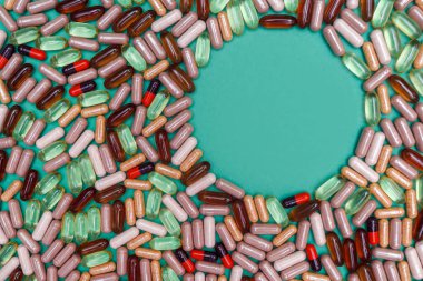 yeşil arka planda çok renkli haplar ve kapsüller