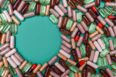 yeşil arka planda çok renkli haplar ve kapsüller