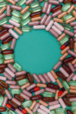 yeşil arka planda çok renkli haplar ve kapsüller