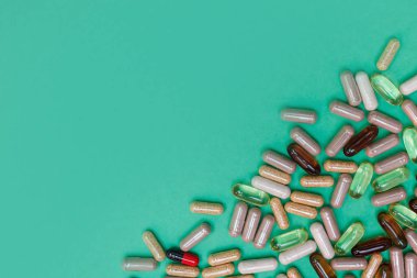 yeşil arka planda çok renkli haplar ve kapsüller