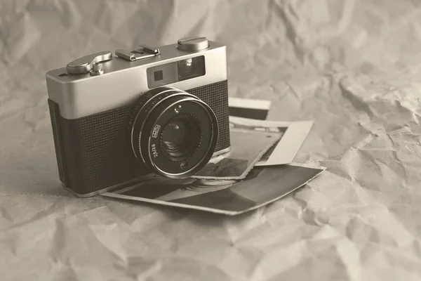 Vintage film camera on crumpled paper background