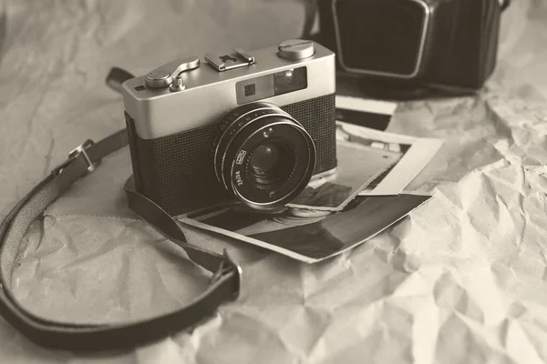 Vintage film camera on crumpled paper background