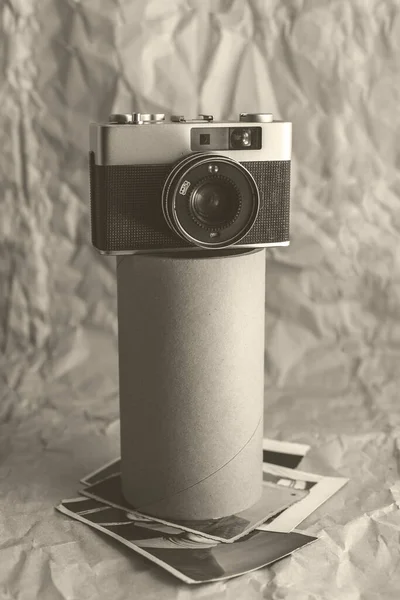 Vintage film camera on crumpled paper background