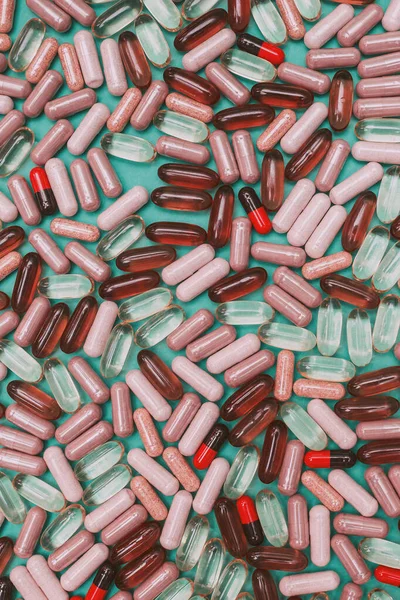 yeşil arka planda çok renkli haplar ve kapsüller