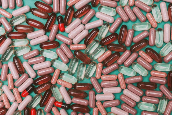 yeşil arka planda çok renkli haplar ve kapsüller