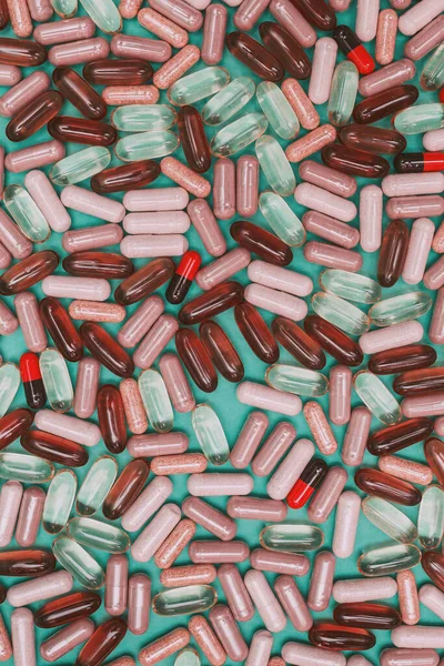 yeşil arka planda çok renkli haplar ve kapsüller