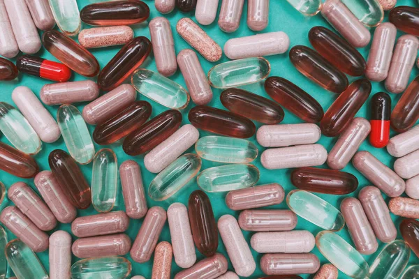 yeşil arka planda çok renkli haplar ve kapsüller