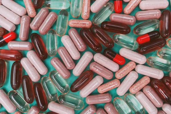 yeşil arka planda çok renkli haplar ve kapsüller