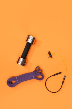 Masaj merdiveni spor emniyet kemeri turuncu arka planda elma ve havlu.